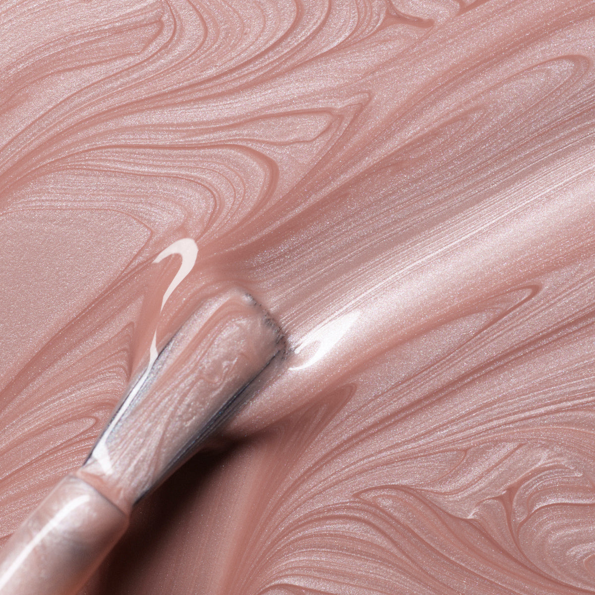 A close-up of a brush spreading Manucurist&
