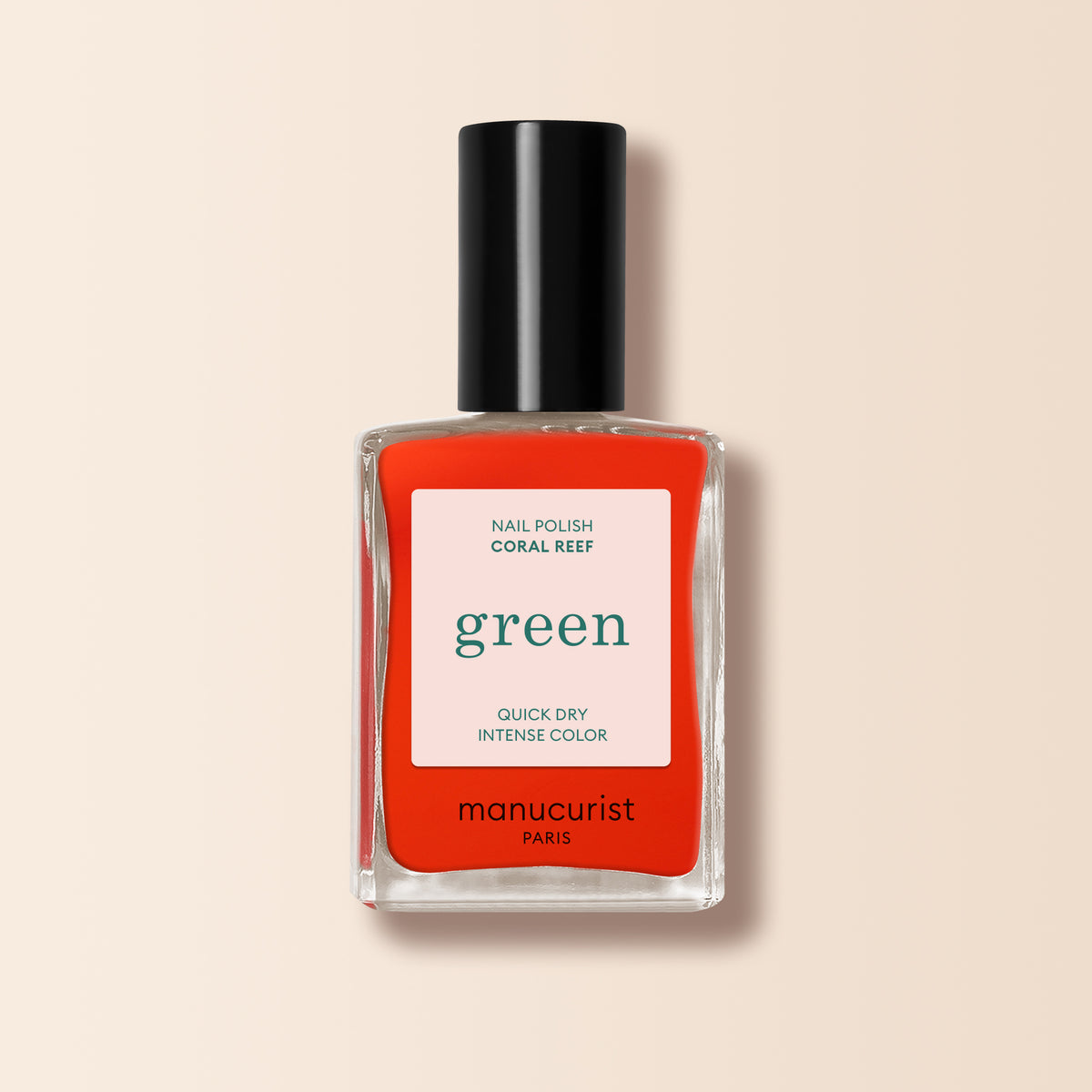 A bottle of Manucurist Coral Reef, a vibrant reddish-orange nail polish, is shown with a black cap and white label on a light beige background.