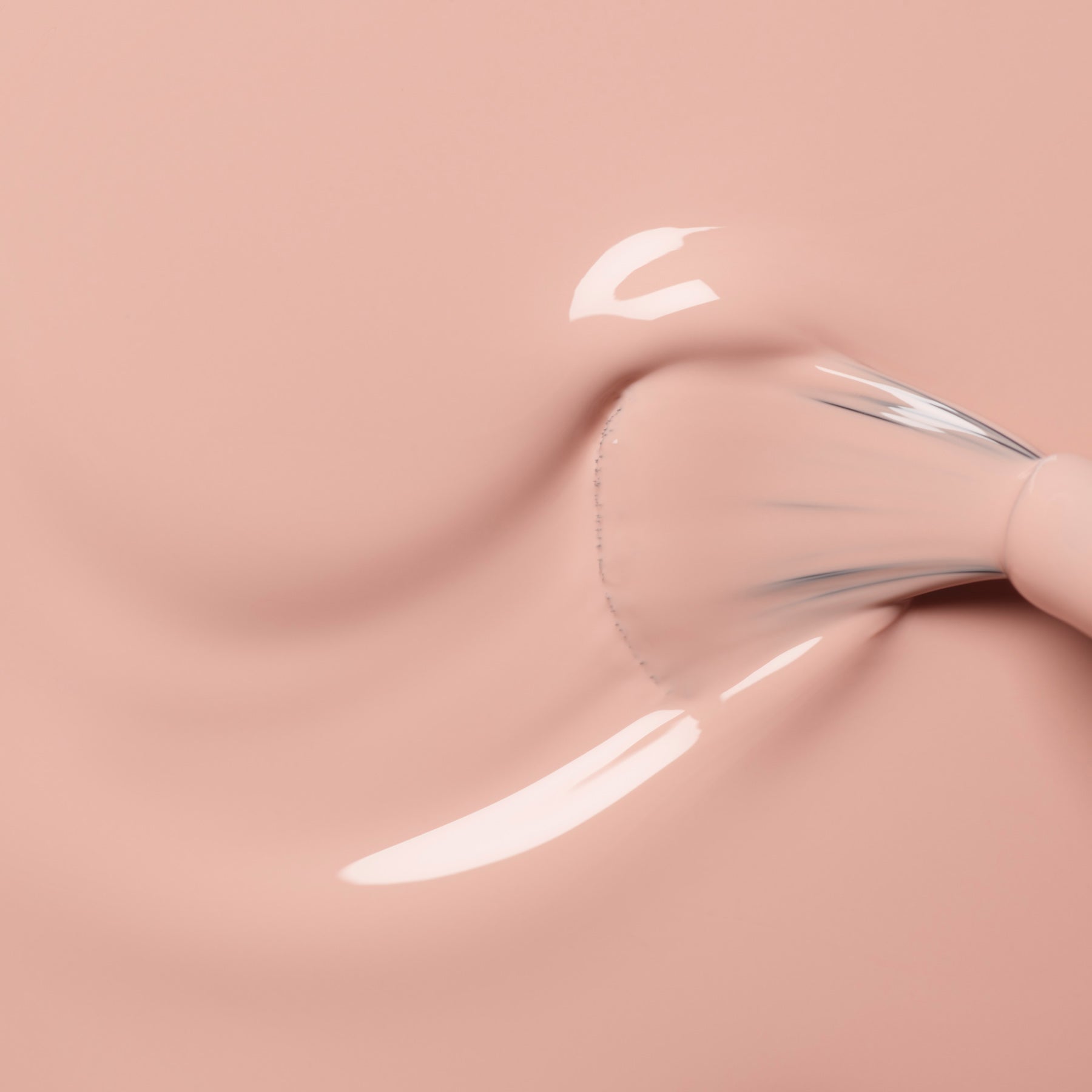 A close-up of a Manucurist Dune brush applying glossy, light pink shimmer nail polish on a smooth surface.
