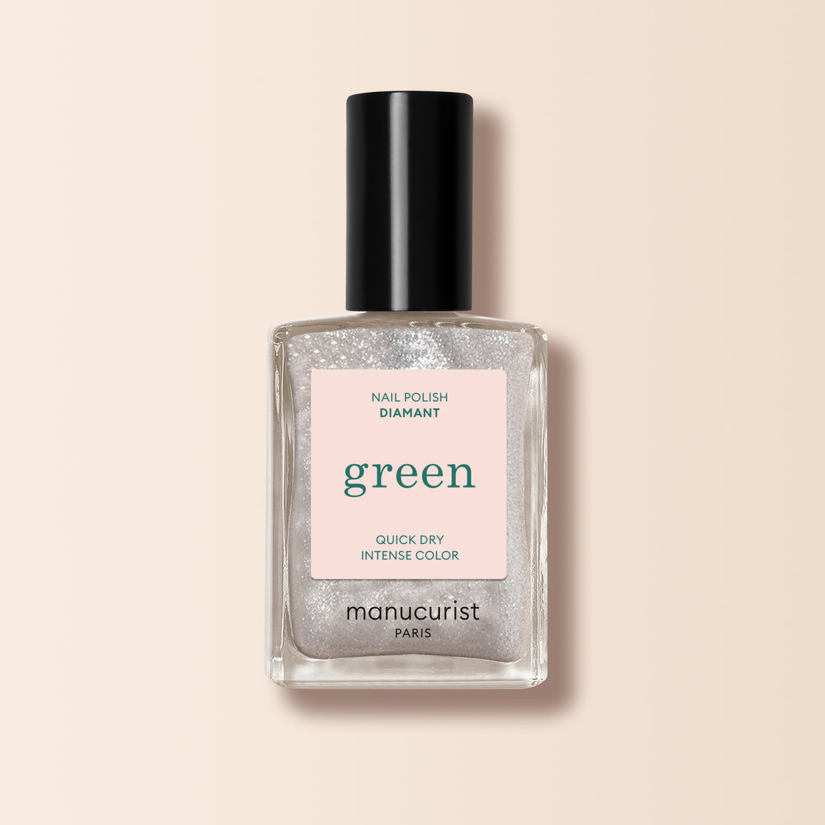 A clear glass bottle of Manucurist nail polish named Diamant, featuring a black cap and label marked "Nail Polish Diamant, Green range, Quick Dry Intense Color." The glittery silver shade provides a sparkling finish for your nails.