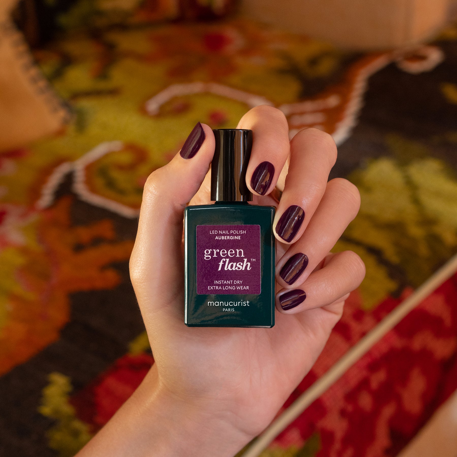 A hand holds a bottle of Manucurist&