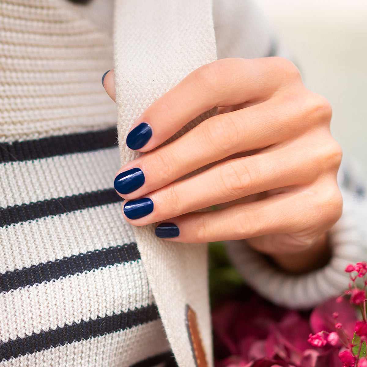 A hand with neatly manicured nails painted in Manucurist&