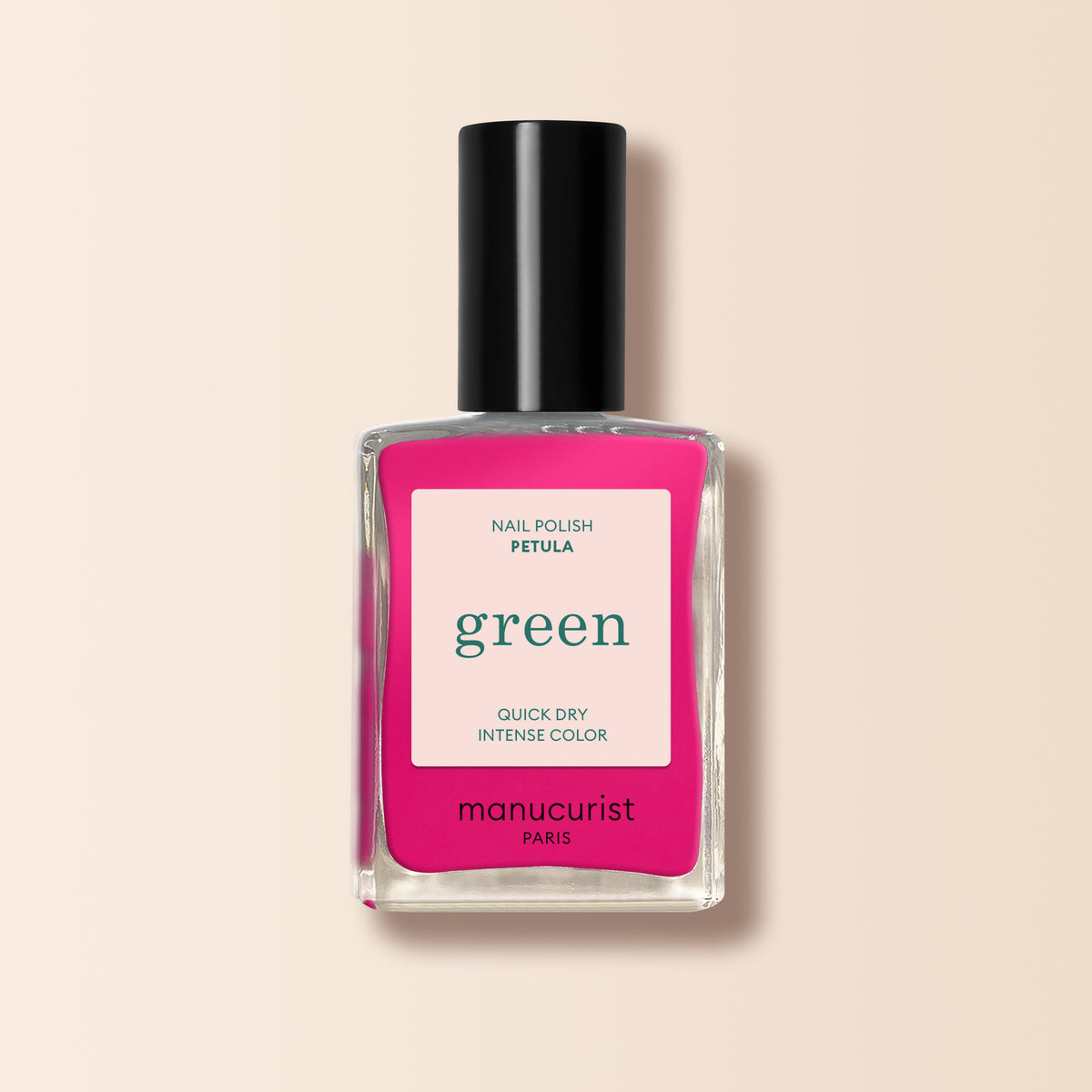A bottle of Manucurist Pétula pink nail polish from the Green™ range, with vibrant pink and blue undertones, a black cap, and a square label reading "green," "quick dry," and "intense color" against a light beige background.