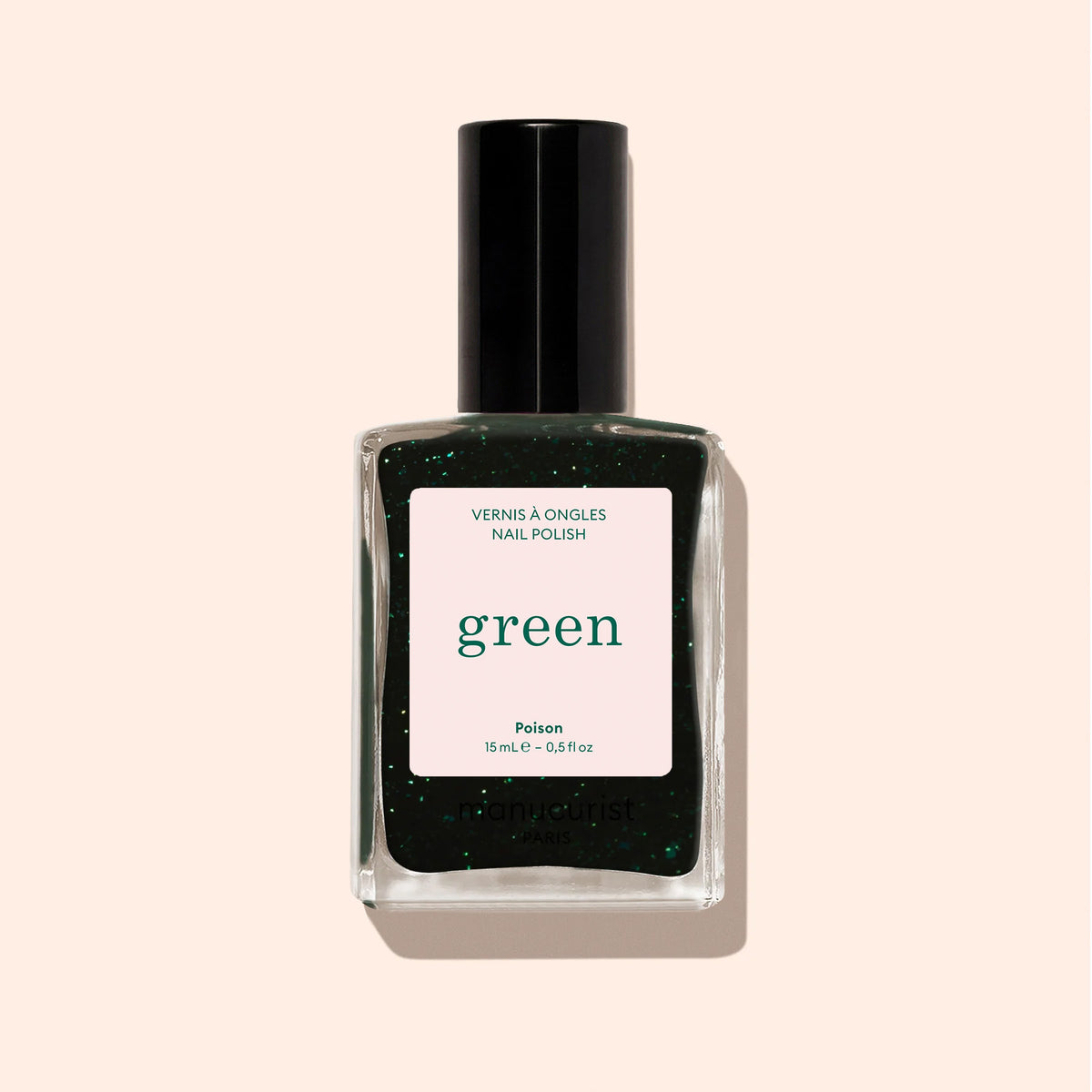 A bottle of Manucurist Nail Polish in Poison, a forest green shade with subtle glitter, features a black cap and square label reading "Poison" and "Quick Dry Intense Color" set against a beige background.