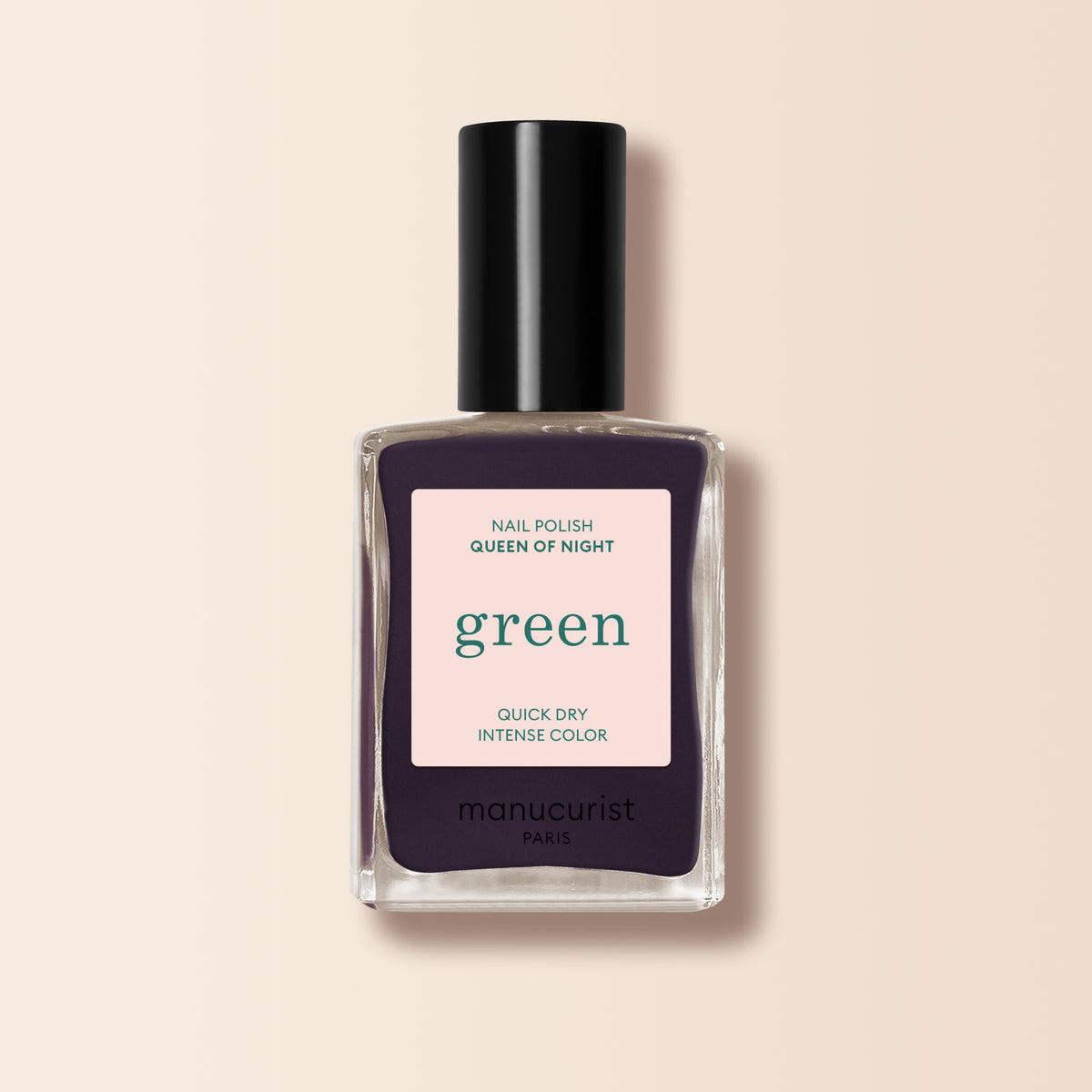 A bottle of Manucurist Queen of Night nail polish, with a bold "green" label and black cap, displayed against a beige background.