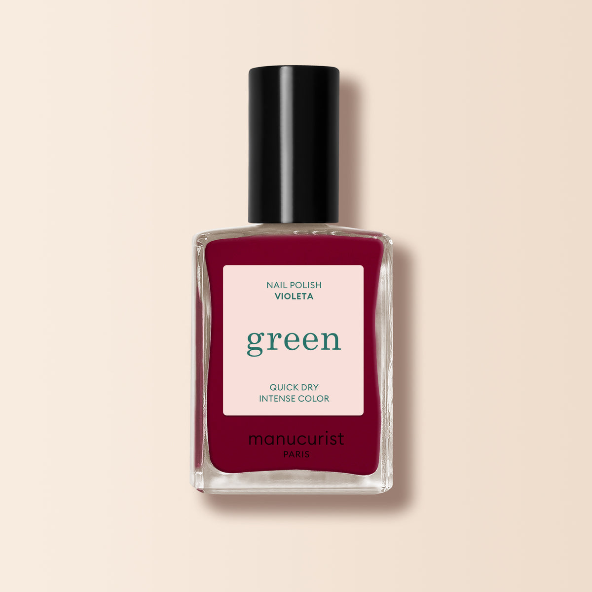 A bottle of Manucurist nail polish in the shade Violeta, a rich burgundy purple, is shown with a black cap against a pale beige background.