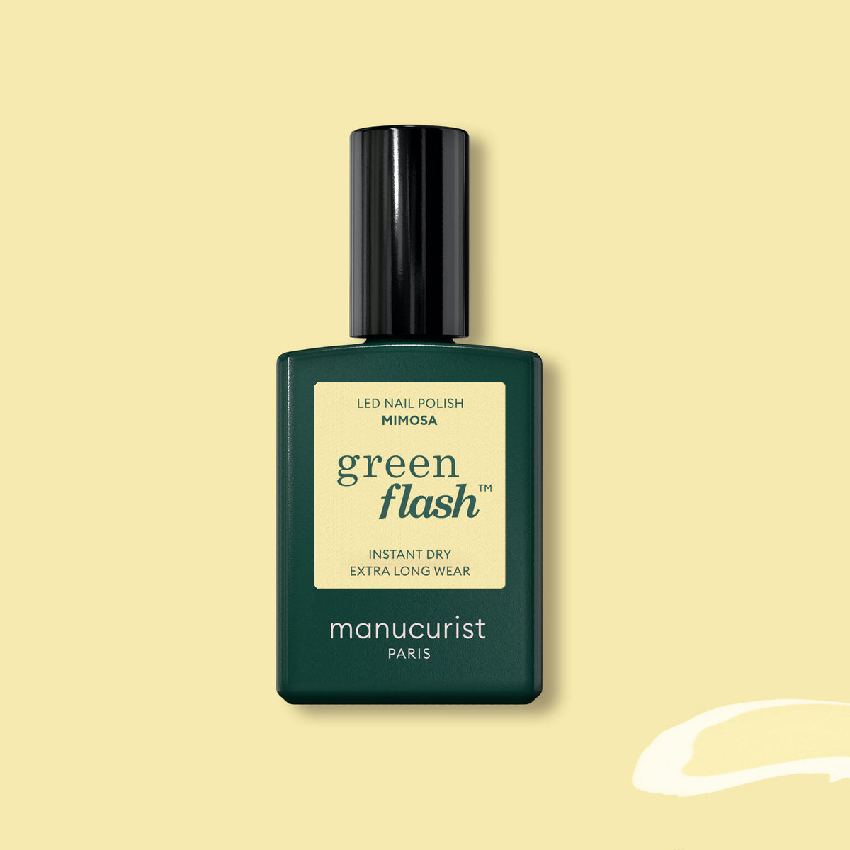 A bottle of Manucurist Mimosa Green Flash gel polish, with a dark green rectangular base, black cap, and light yellow label, is displayed against a pastel yellow background.