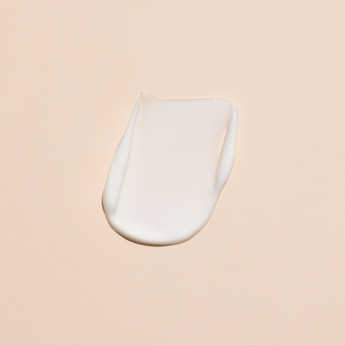 A smear of Manucurist Lavande Vraie Hand Cream - Cosmos Organic, with a delicate lavender scent, is spread on a smooth, light beige surface.