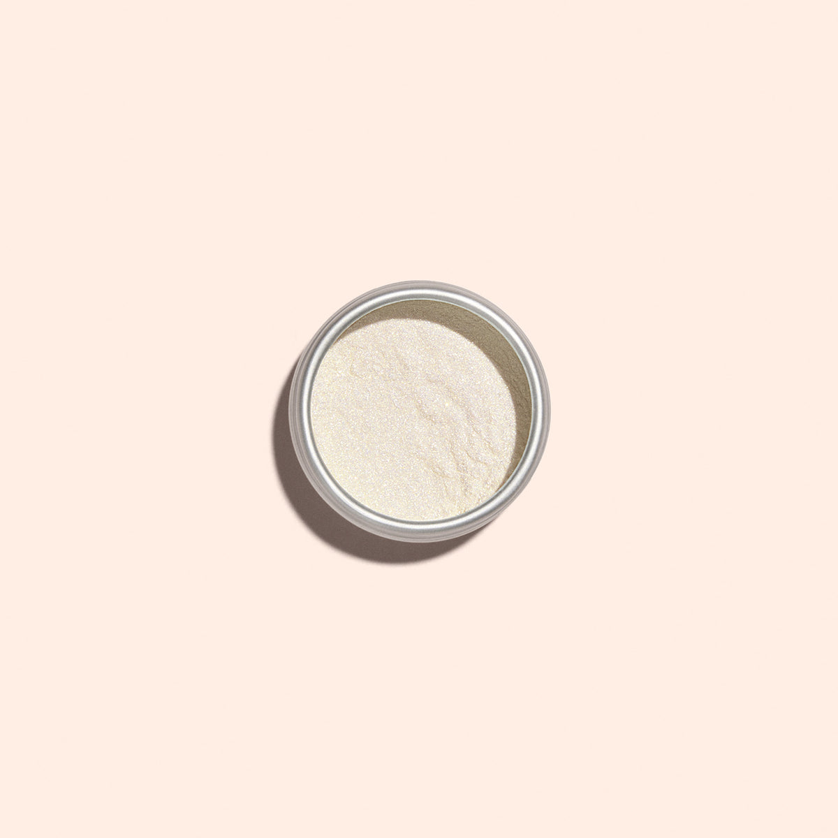 A small round metal tin of Manucurist Golden Glazed Powder is shown from above on a plain light beige background. The fine, off-white powder delivers a pearly gold shimmer for an elegant Golden Glazed Effect Powder finish.