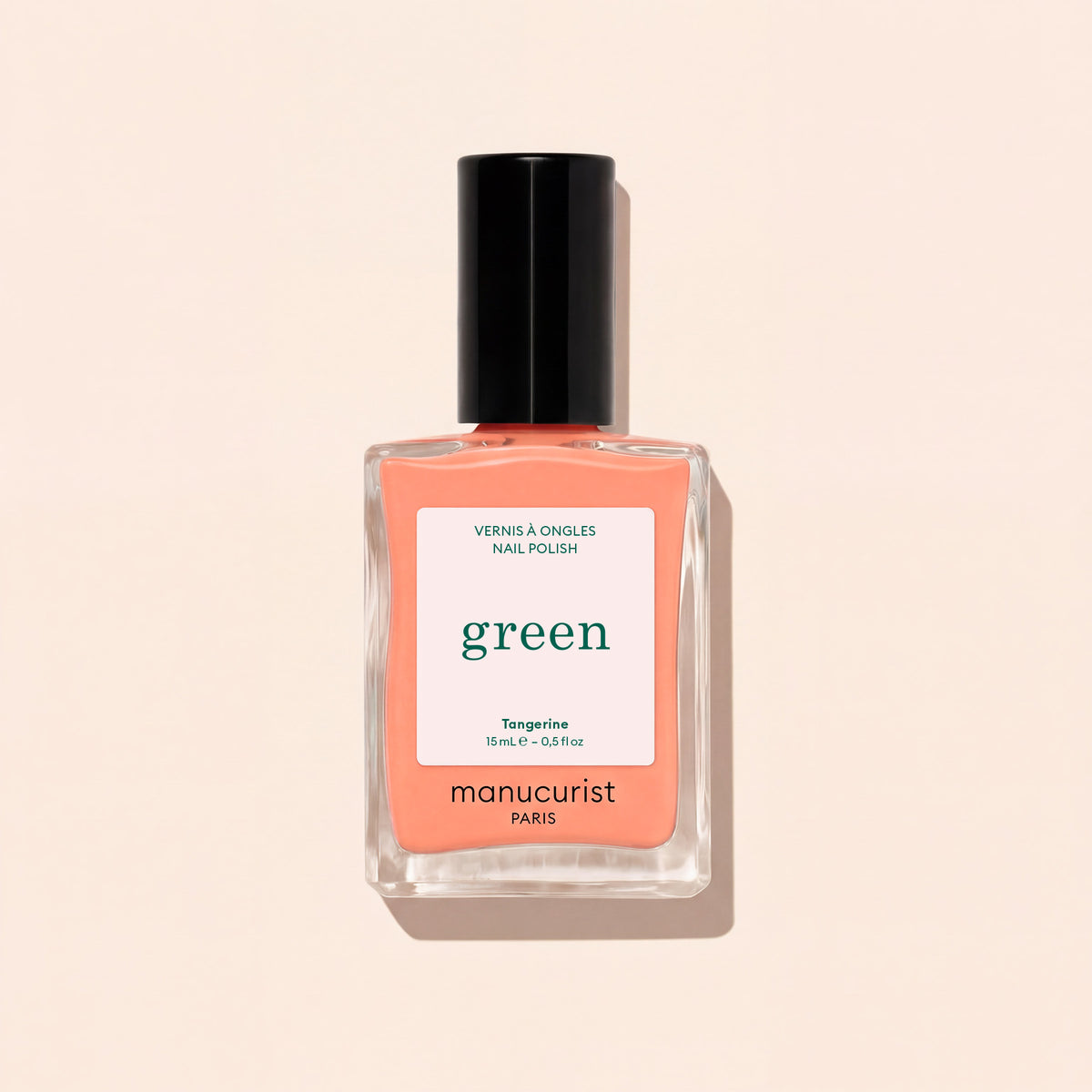 A bottle of Manucurist Tangerine nail polish, a neon light orange shade, features a black cap and minimalist label, displayed on a light beige background.