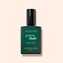 A green bottle of Manucurist Vitaminised Base Coat Green Flash™ with a black cap is shown against a light beige background.
