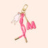 The Manucurist Jelly Charm features a gold clip, pink cord with gold-tipped ends, a peace hand sign charm, and a pink letter M Jelly Charm—reminiscent of jelly nail polish—set on a light beige background.