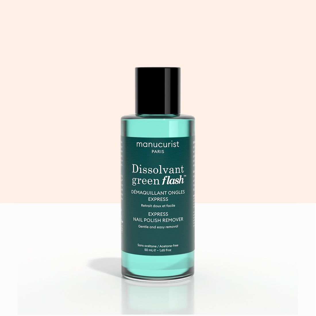 A bottle of Manucurist Customisable Trio Green Flash, featuring teal liquid, is displayed against a light pink and white background.