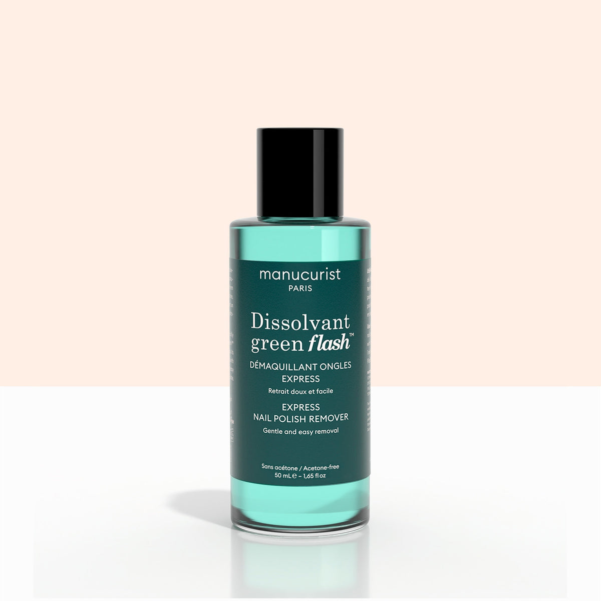 A bottle of Manucurist Customisable Trio Green Flash, featuring teal liquid, is displayed against a light pink and white background.