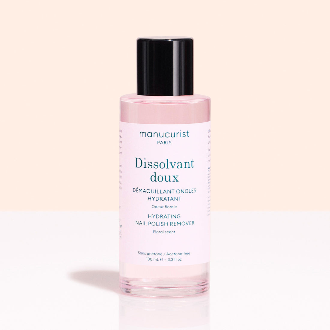 A pink bottle from Manucurist’s Green™ Base, Top Coat  Nail Polish Remover Trio with a black cap sits on a light background. The acetone-free, floral-scented formula hydrates and cares for nails after green or gel-effect manicures.