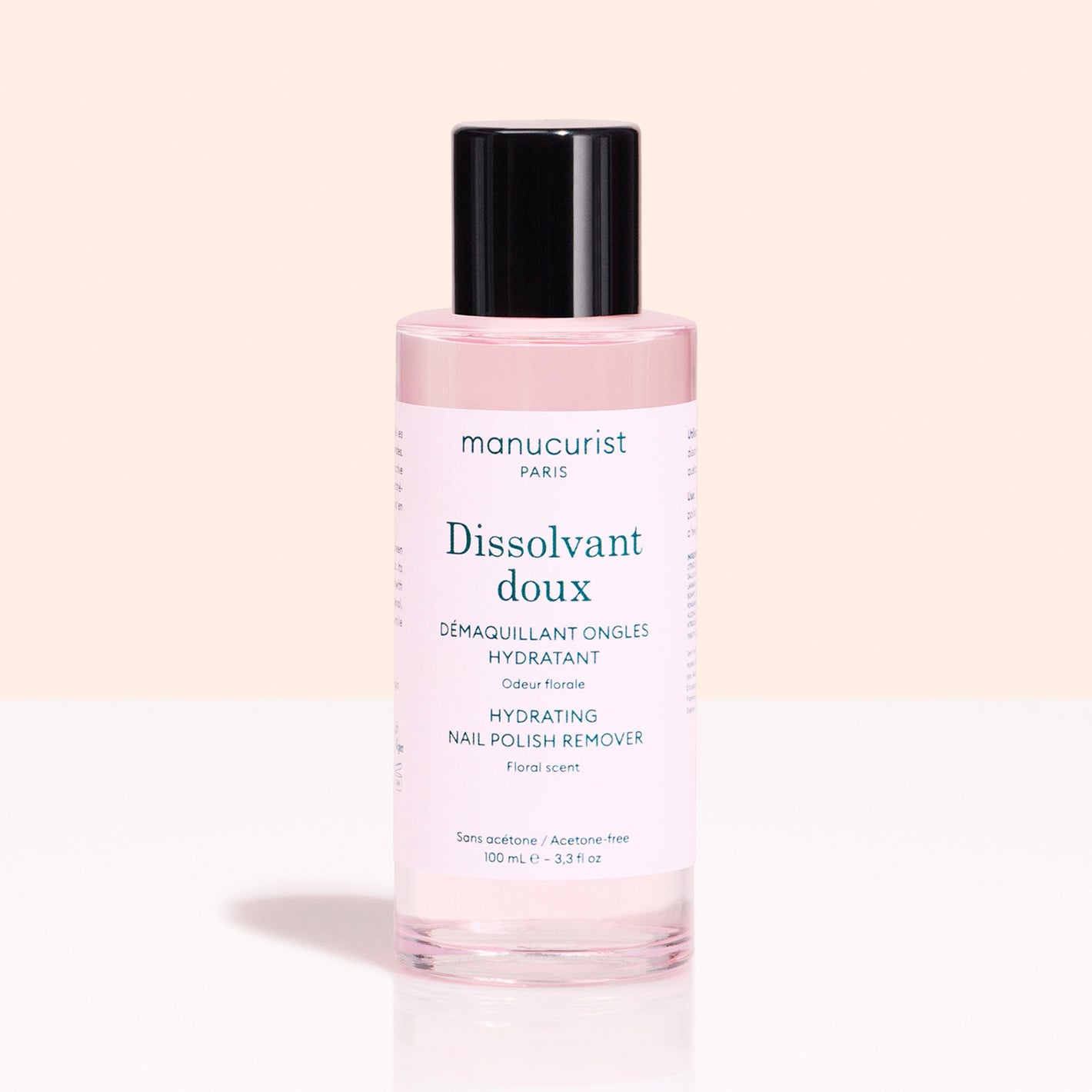 A pink bottle from Manucurist’s Green™ Base, Top Coat  Nail Polish Remover Trio with a black cap sits on a light background. The acetone-free, floral-scented formula hydrates and cares for nails after green or gel-effect manicures.