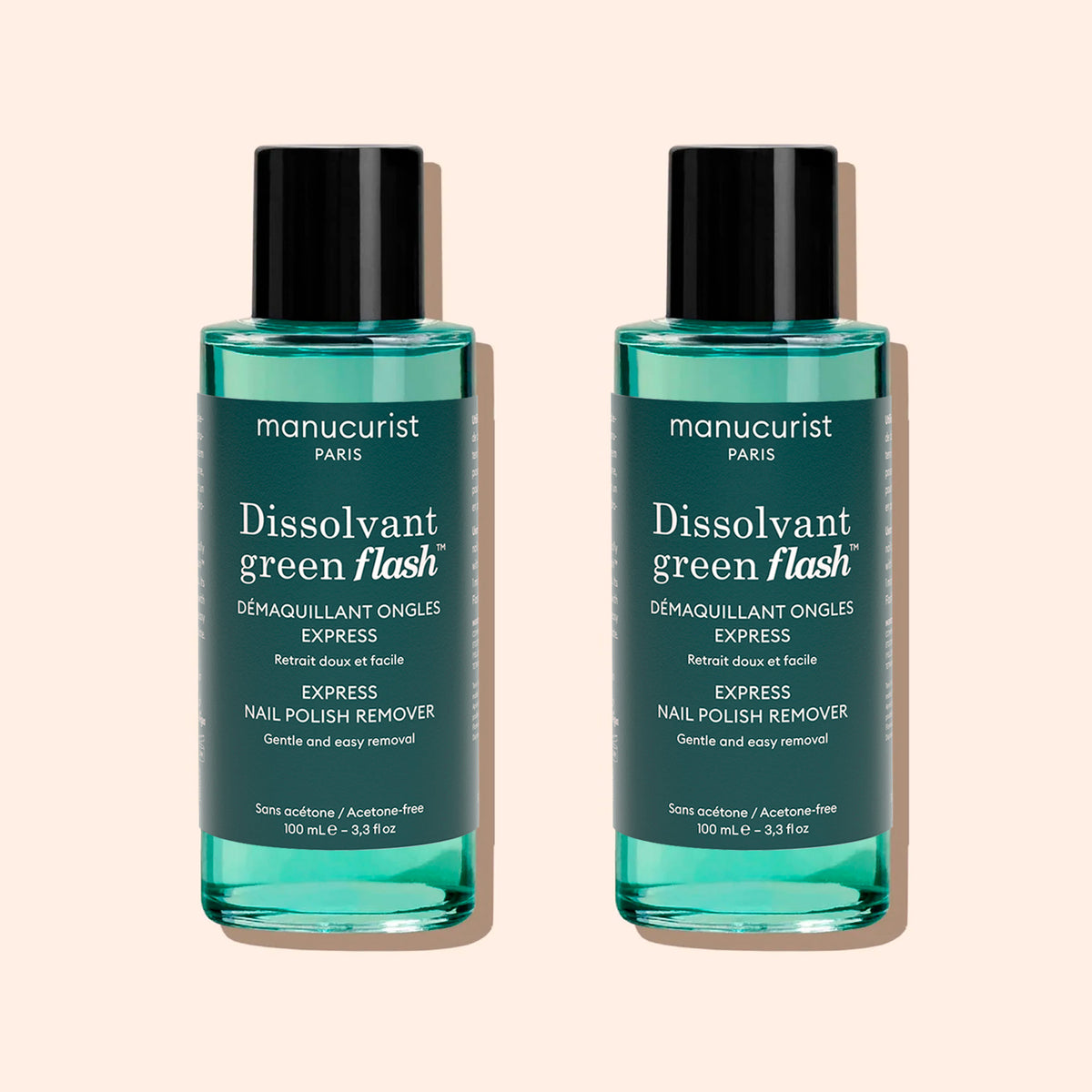 Two bottles of Manucurist Green Flash™ Gel Polish Remover, featuring teal liquid, black caps, and white label text, are displayed against a light beige background.