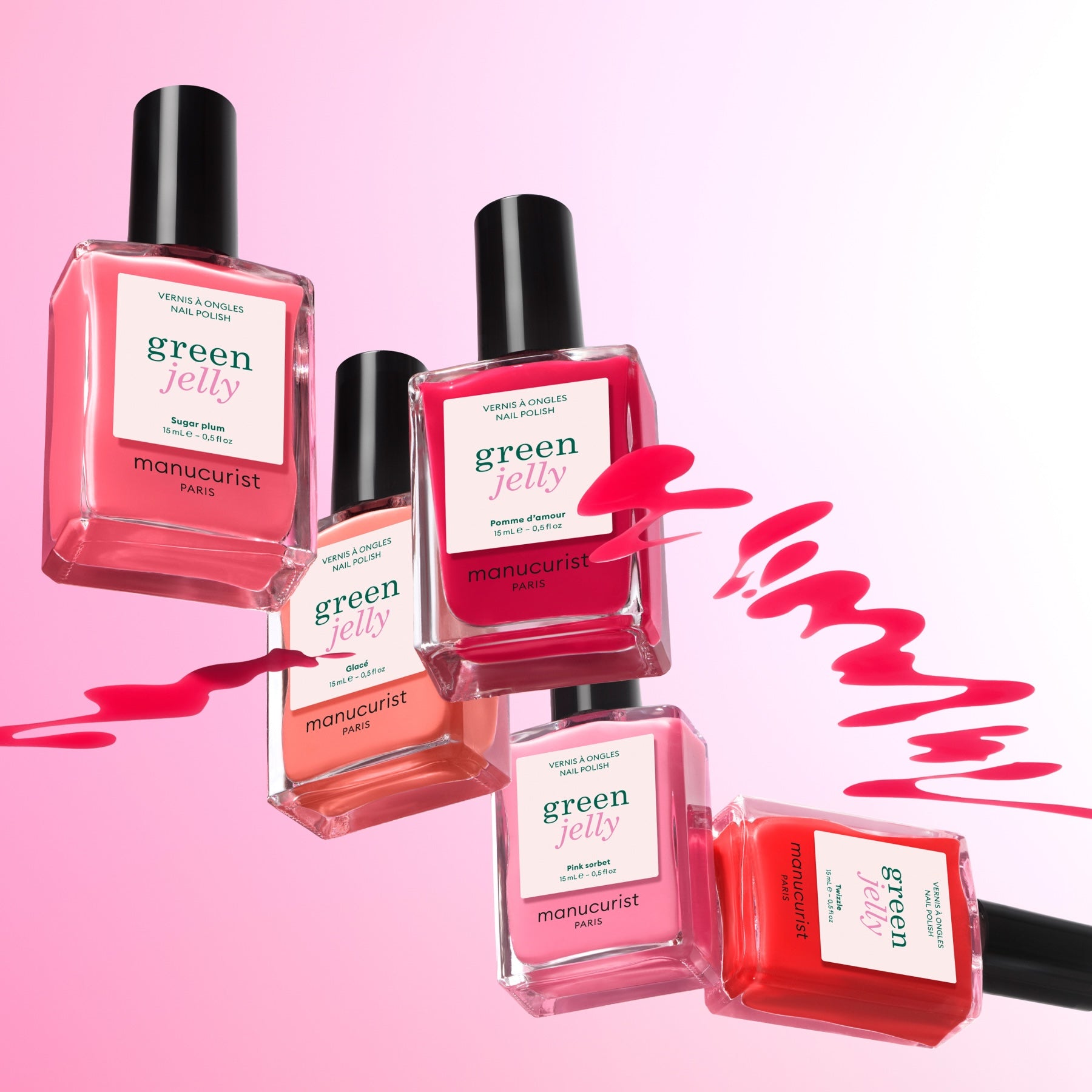 Six bottles of Manucurist Rainbow Collections nail polish in pink, red, and orange float on a pink gradient background with swirling colors—ideal for trendy manicures and curated colour palettes.