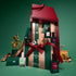 Manucurist Advent Calendar Time to Flash! box features manicure essentials, including gel nail polishes for a flawless manicure, cuticle oil, and a Keratine booster. Decorative gold ornaments and figurines surround the box, set against a green background.
