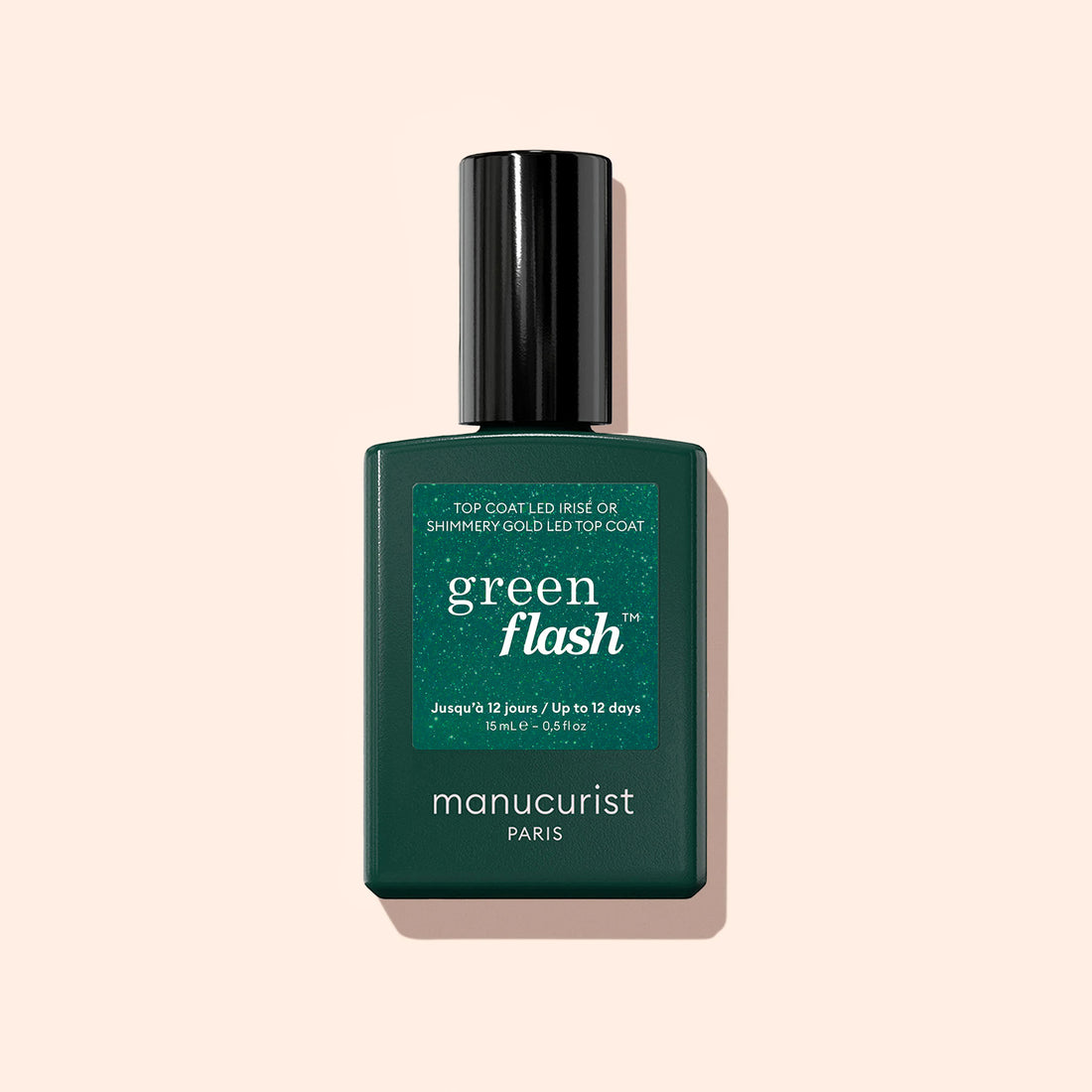 Manucurist Glitter Top Coat nail polish in a dark green rectangular bottle with a black cap is shown against a light beige background, offering a long-lasting, glittery manicure.