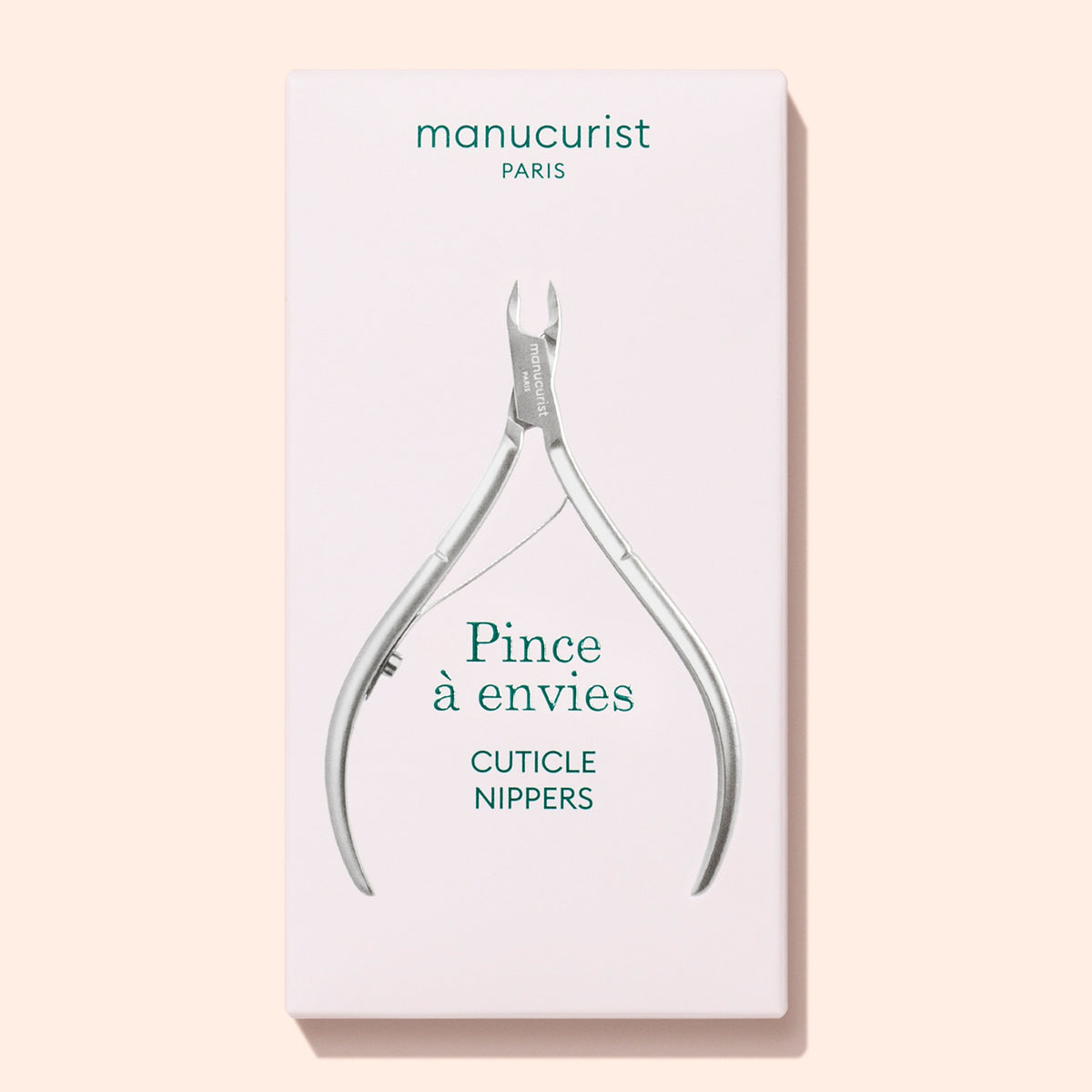A box of Manucurist Cuticle nippers, featuring the product name “Cuticle nippers” and the brand “Manucurist,” displays an image of the stainless steel tool on the front set against a light pink background.