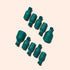 Nine Manucurist Foot Removal Clips, in dark green silicone, are arranged diagonally on a light beige background, casting shadows to the upper left.