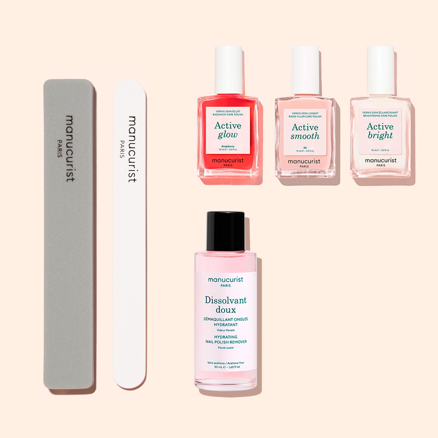 The Active™ Manicure Kit by Manucurist, featuring two nail files, three bottles of nail care polish, and one bottle of nail polish remover from their premium collection, is beautifully displayed on a beige background. Ideal for an at-home manicure or as a comprehensive nail treatment set.