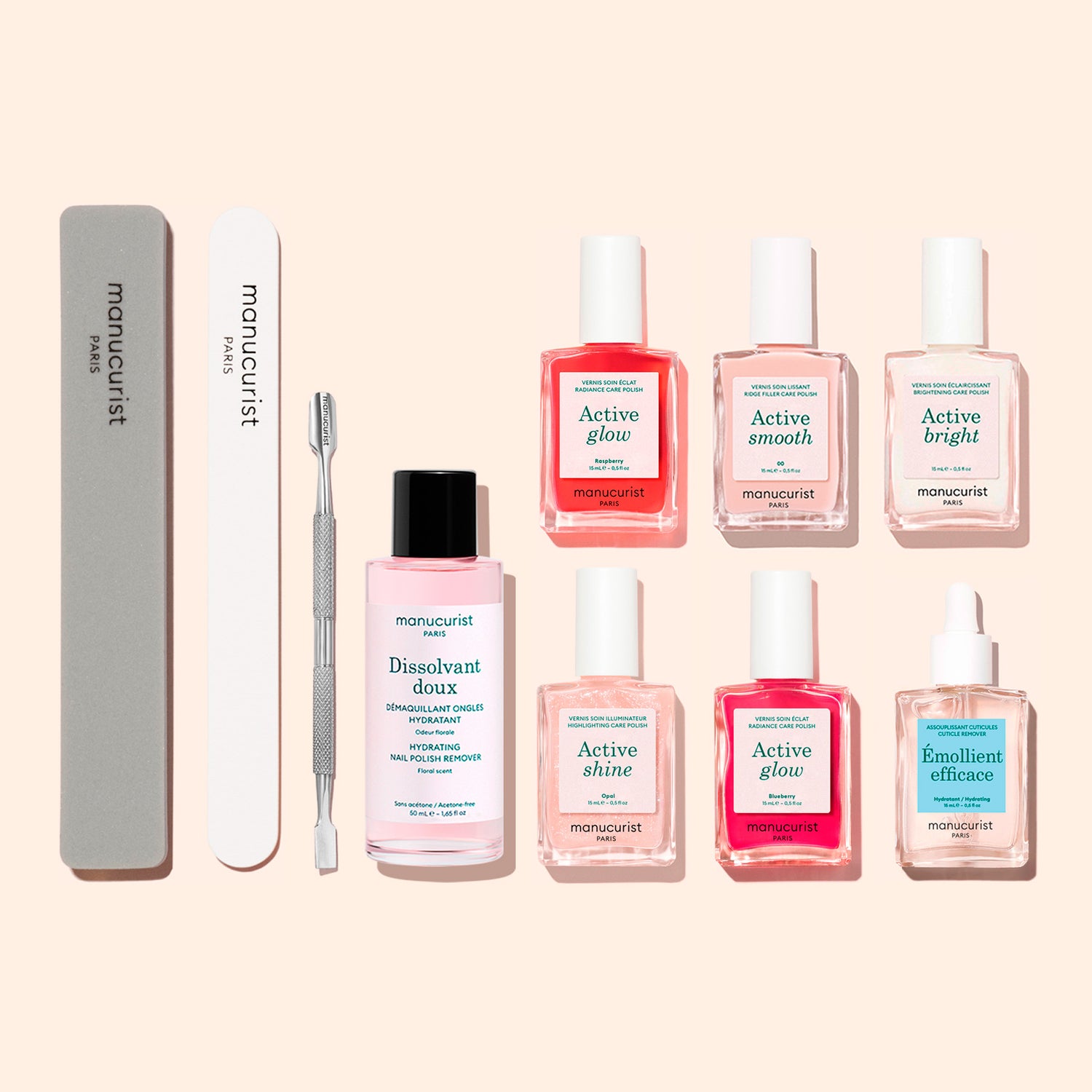 The Manucurist Active™ Super Manicure Kit features a comprehensive selection of nail care essentials, including files, a cuticle pusher, nail polish remover, four bottles of nail treatments, a nourishing dropper-bottle serum, and an extra treatment bottle—all elegantly arranged on a light background.