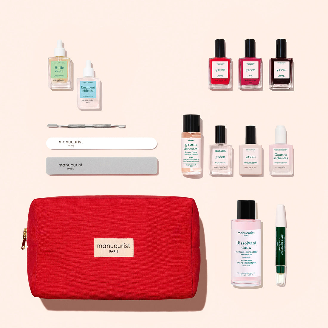 The Manucurist Addict Kit—a red pouch filled with essential manicure tools, including nail files, polish bottles, oil, remover, a cuticle tool, a green pen, and a buffer—is artfully arranged on a beige background for an effortless at-home manicure experience.