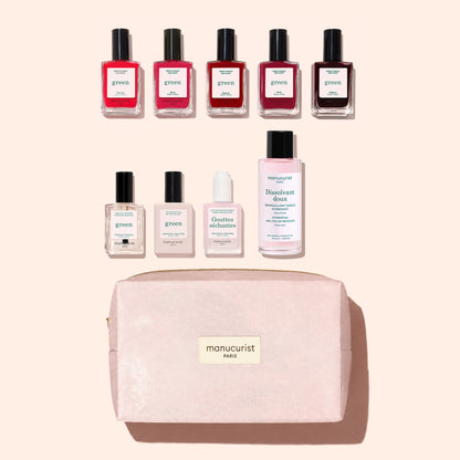 Nine bottles from the Manucurist Super Starter Kit and a light pink Manucurist Paris bag are arranged neatly on a beige background. The kit includes gel-effect nail polish, base coat, top coat, drops, and remover—offering everything you need for the perfect at-home Green manicure pampering session.