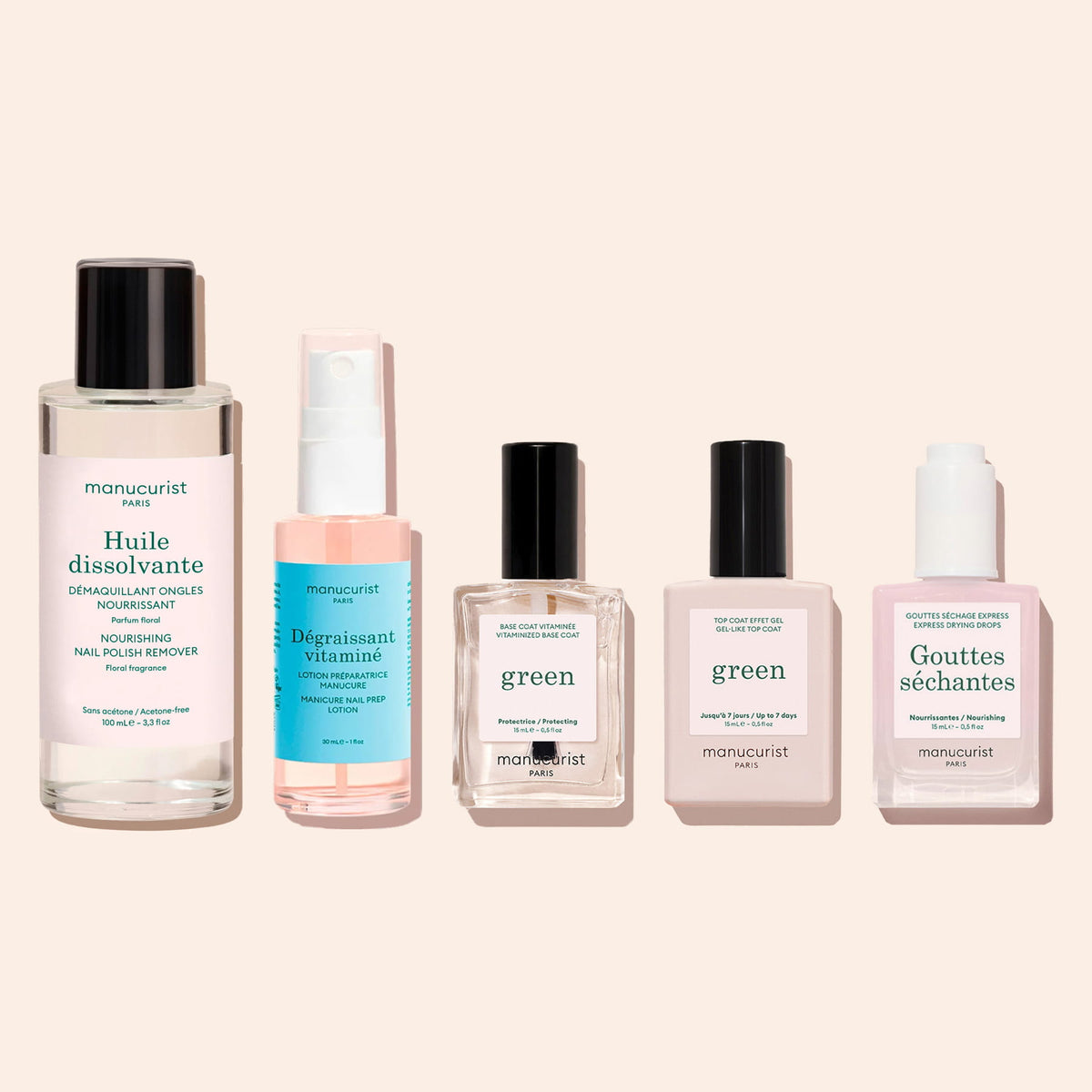 Five nail care products arranged in a row: Manucurist Green Nail Polish Removing Oil, a spray bottle of prep lotion, a clear base coat, a top coat, and a bottle of drying drops.