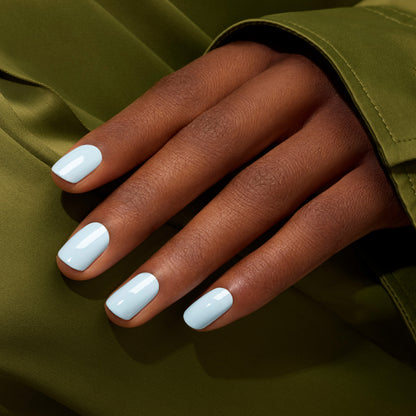 A hand with medium brown skin shows neatly manicured nails painted with Manucurist&