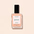 A bottle of Manucurist Milky Peach nail polish from the Green collection—a soft orange beige shade—featuring a black cap and “green” label, is displayed against a light beige background.