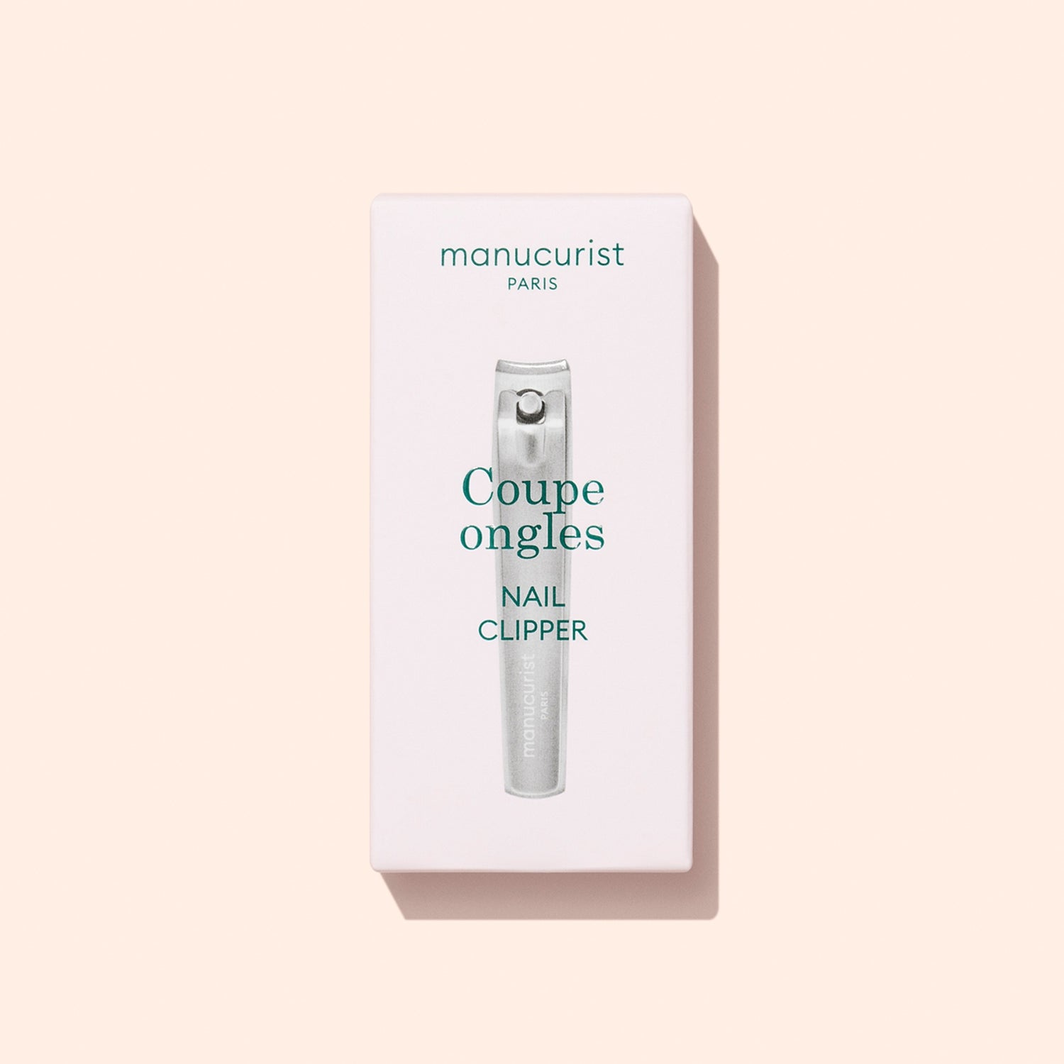 A box of Manucurist Nail Clipper is displayed on a light beige background. The packaging features an image of the nail clipper along with text in French and English, highlighting it as the ideal tool for maintaining natural nails and achieving a flawless manicure.