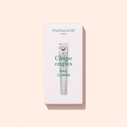 A box of Manucurist Nail Clipper is displayed on a light beige background. The packaging features an image of the nail clipper along with text in French and English, highlighting it as the ideal tool for maintaining natural nails and achieving a flawless manicure.