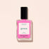 A bottle of Manucurist nail polish in the shade Bloom, neon pink with blue undertones and a black cap, is shown on a light beige background. The label displays “green” and “VERNIS À ONGLES NAIL POLISH.”.