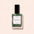A bottle of Manucurist Groove nail polish in a metallic green shade is displayed against a pale beige background. The label shows "VERNIS À ONGLES NAIL POLISH green Groove 15 ml e .5 fl oz.