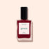A bottle of Manucurist Amour nail polish from the Paris Green range, featuring a luminous burgundy shade and a black cap, displayed on a light beige background.