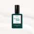 A green bottle of Manucurist gel polish in the shade Bliss rests on a white, slightly textured background. The label displays the shade name “Bliss” and indicates a size of 15 mL.
