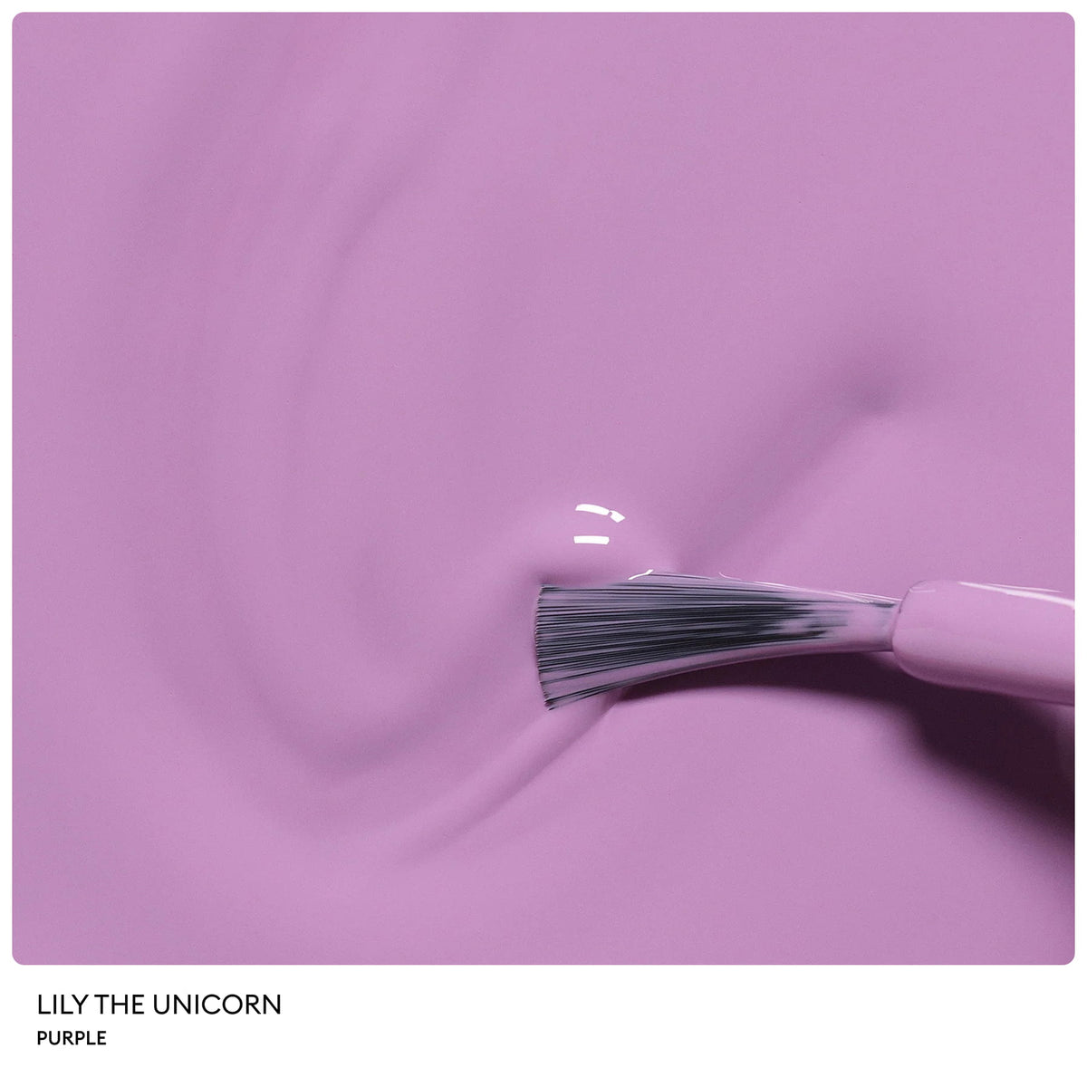 A close-up of a brush applying shiny purple nail polish on a smooth surface. The glossy finish and visible brush bristles highlight the Petite Manucurist Trio by Manucurist—a children’s nail polish made from natural origin ingredients, making it an ideal holiday gift.