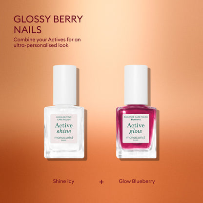 Two travel-size nail polish bottles from Manucurist’s Active™ Travel-Size Duo sit on a gradient pink background: one clear bottle labeled “Active Shine,” and one berry-colored bottle labeled “Active Glow.” Above them, text reads “Glossy Berry Nails,” accompanied by a description that emphasizes the importance of nail care. Labels appear below each bottle. This chic Manucurist set makes the perfect holiday gift for anyone who loves healthy, beautiful nails.