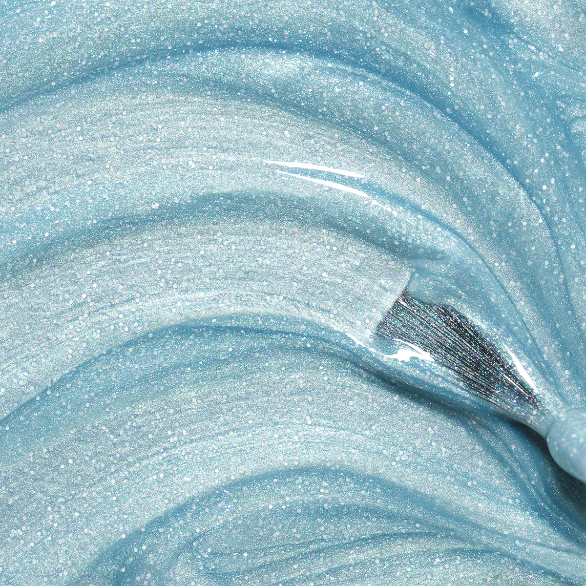 Close-up of Bonnie the Mermaid slime by Manucurist: swirling light blue glitter with shiny, sparkling particles and a smooth, wavy texture—made with ingredients similar to those found in kids’ nail polish.
