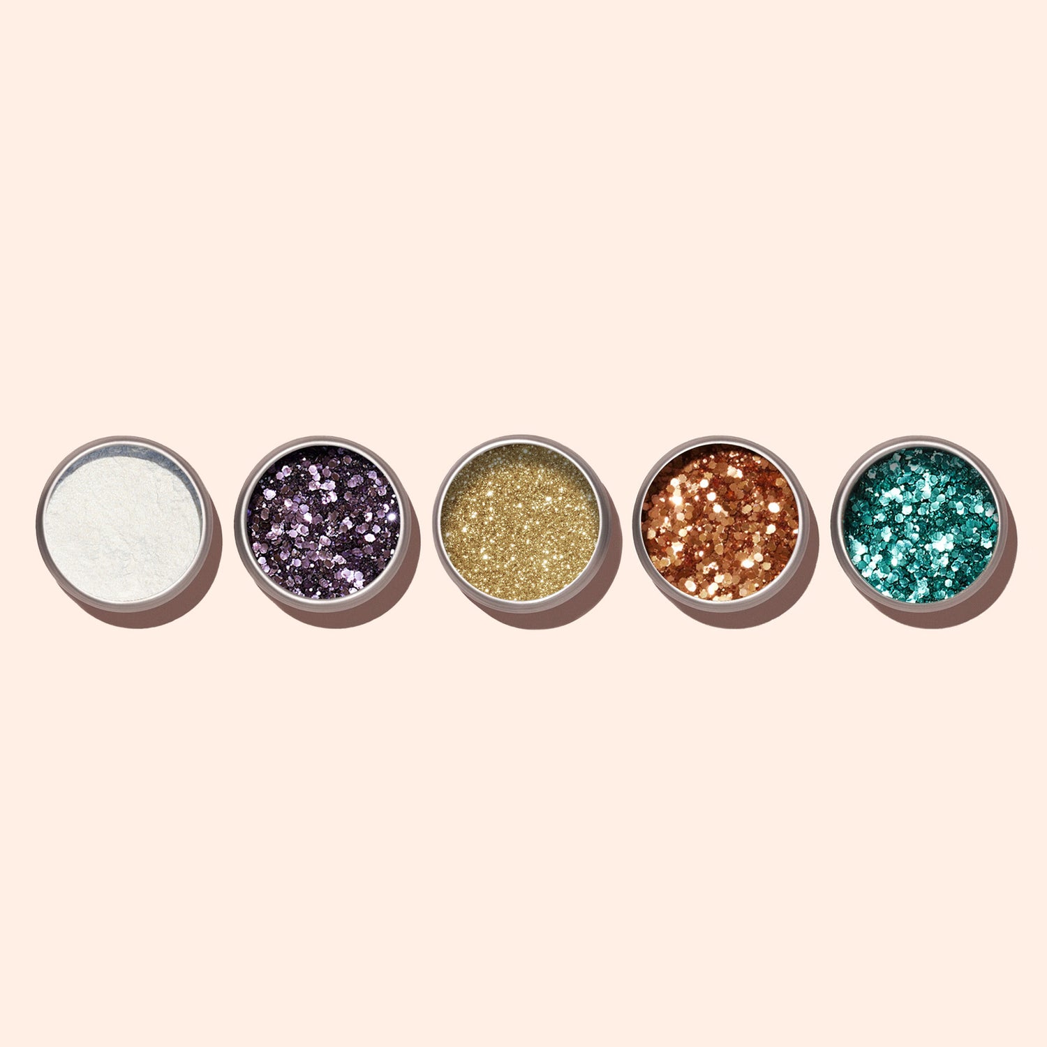 Five small round containers of Manucurist Turquoise biodegradable glitter are arranged in a row on a light beige background, showcasing different sparkling colors and textures—ideal for enhancing your nail art.