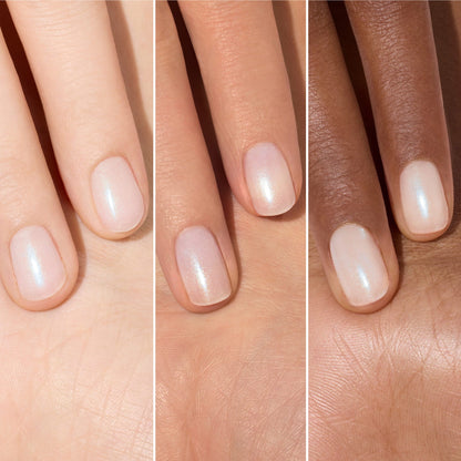 Three hands of varying skin tones display short, manicured nails painted with Manucurist’s Active Plump Aqua Glazed—a sheer, pearlescent white polish—shown side by side to highlight its hydrating, glowing finish.
