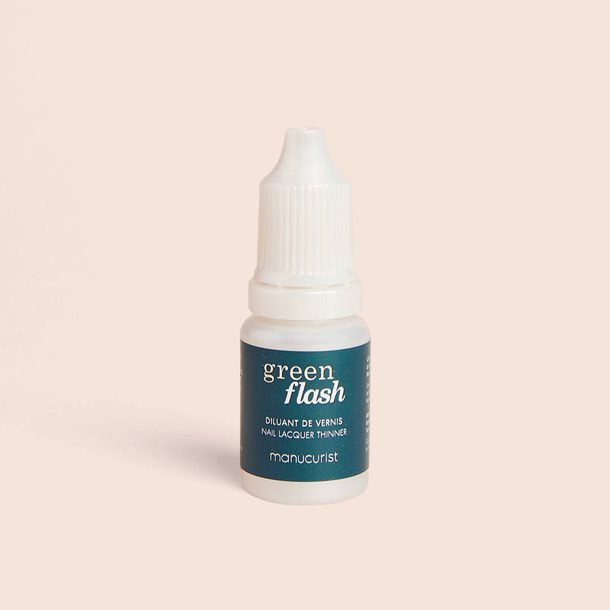A small white bottle of Manucurist Green Flash Diluent with a dark green label stands upright on a light beige background—ideal for extending the life of your manicure.