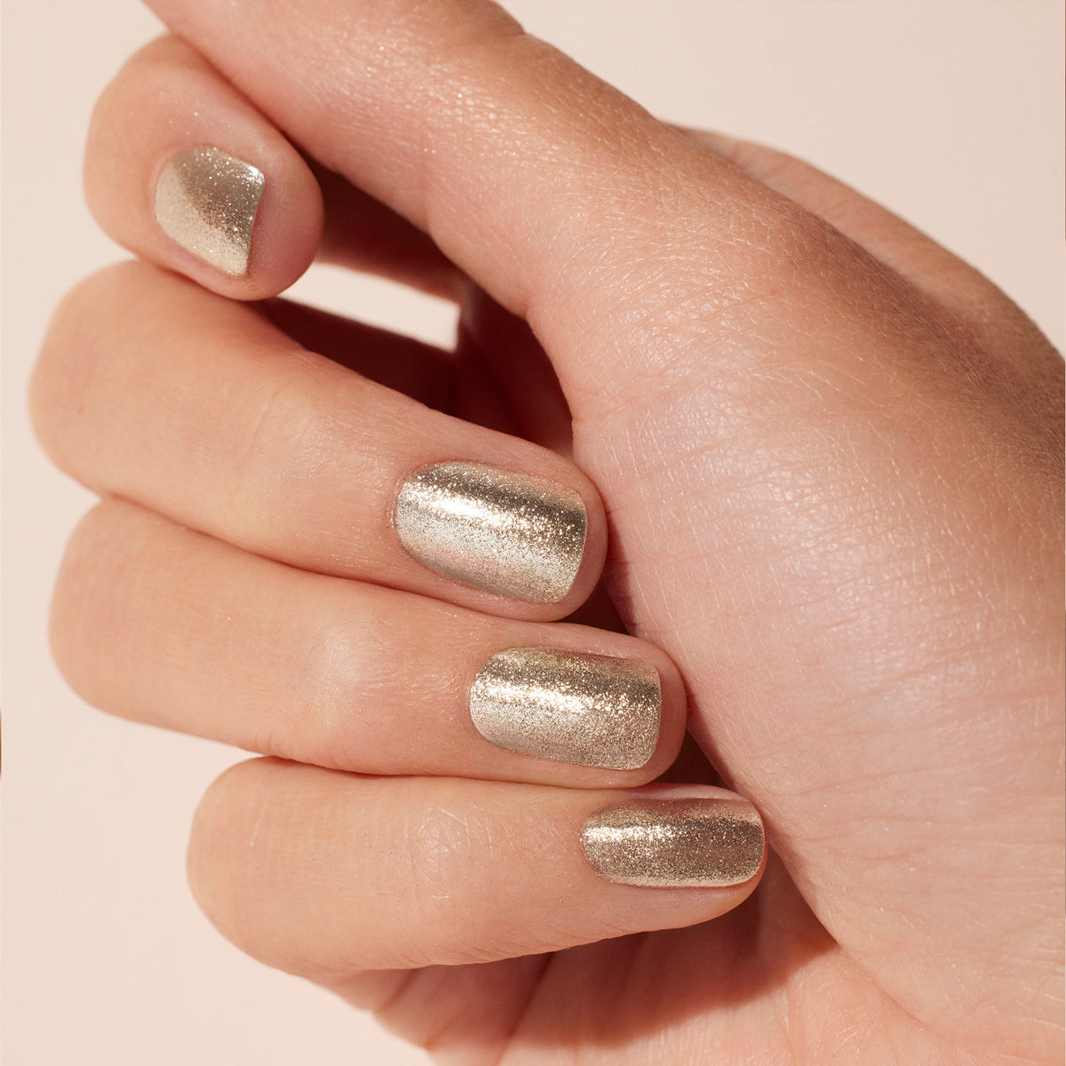 A close-up of a hand with short, neatly shaped nails painted in Manucurist&