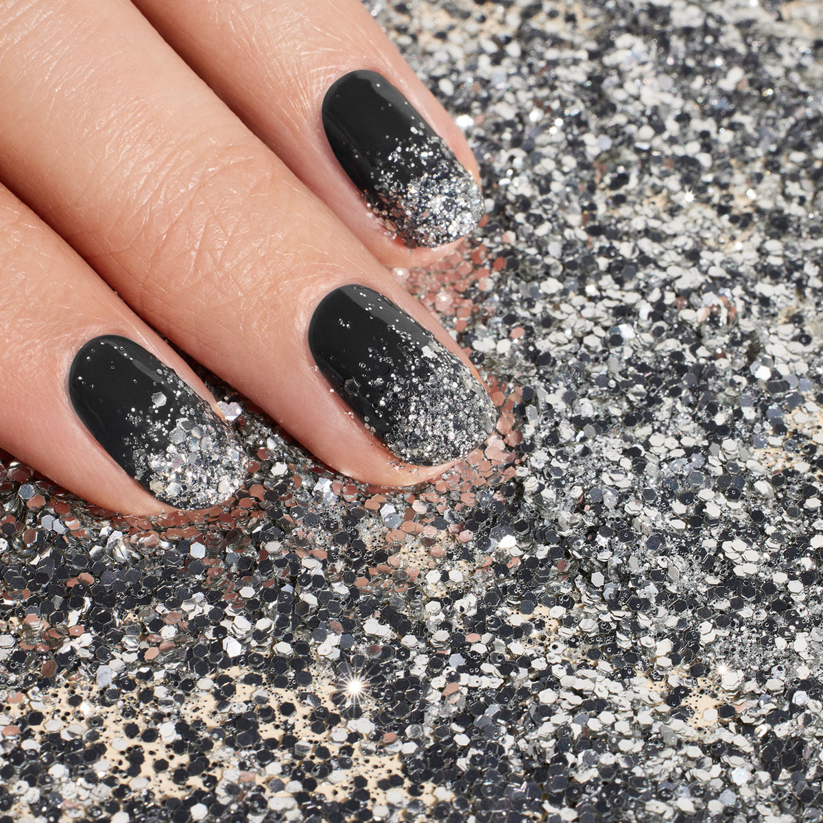 A hand with black nails features Manucurist&