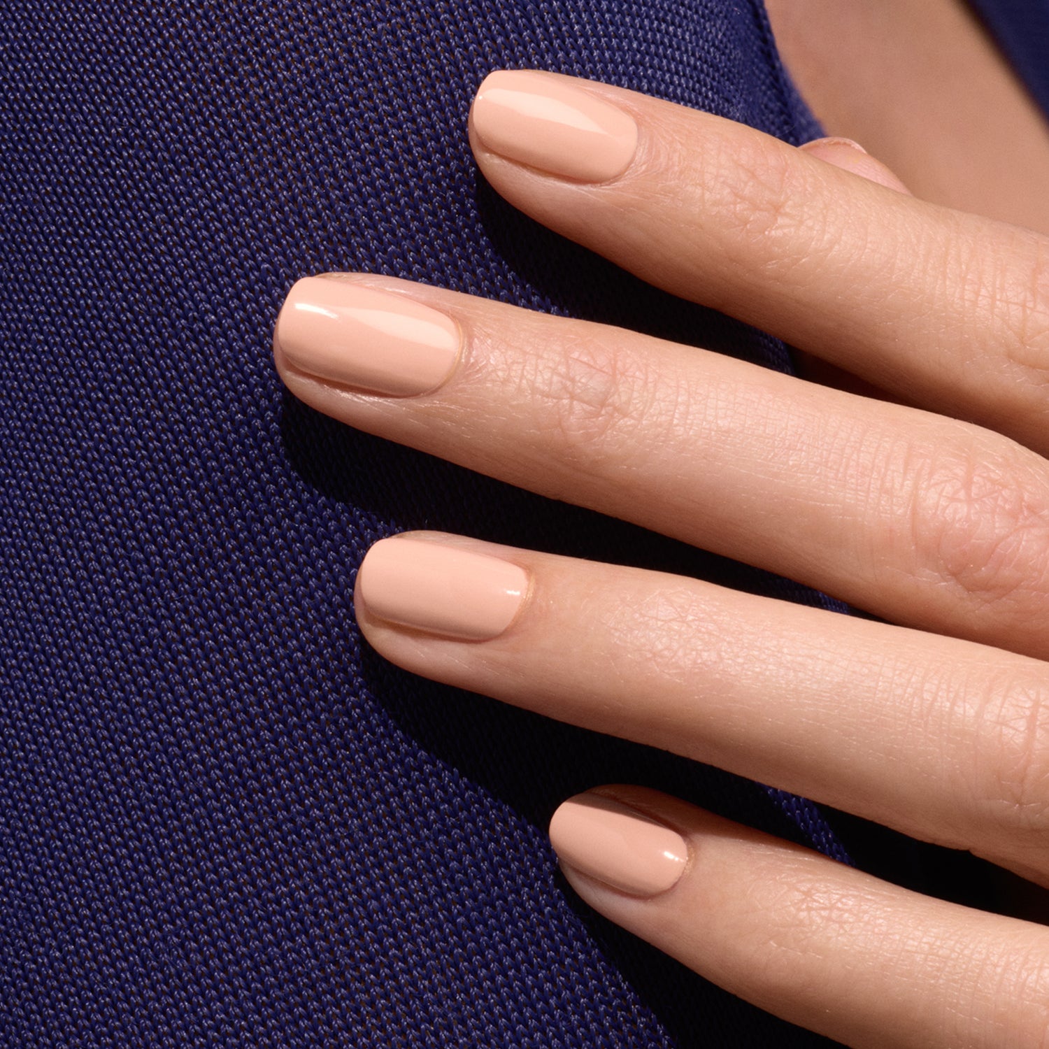 A close-up of a hand with short, neat nails painted in Manucurist&