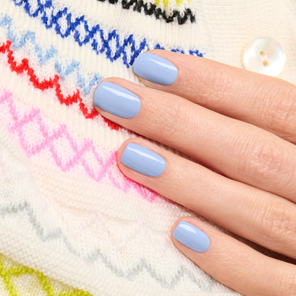 A hand with short, neatly manicured nails painted in Manucurist&