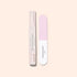The Manucurist Glossy Booster Duo, featuring a gentle nail exfoliator and a pink-and-white nail file, rests on a pale beige background—ideal for achieving glossy nails.